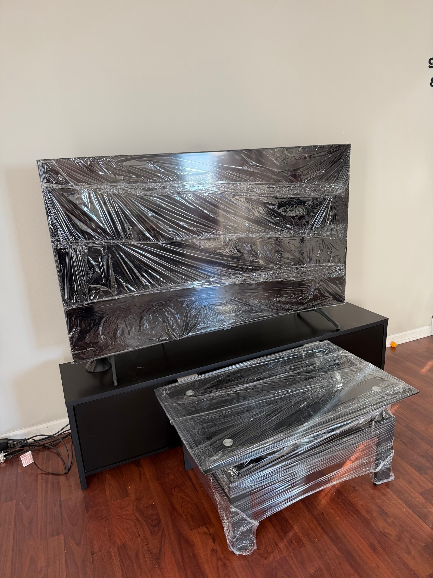 TV and glass table shrink-wrapped and prepped for transport